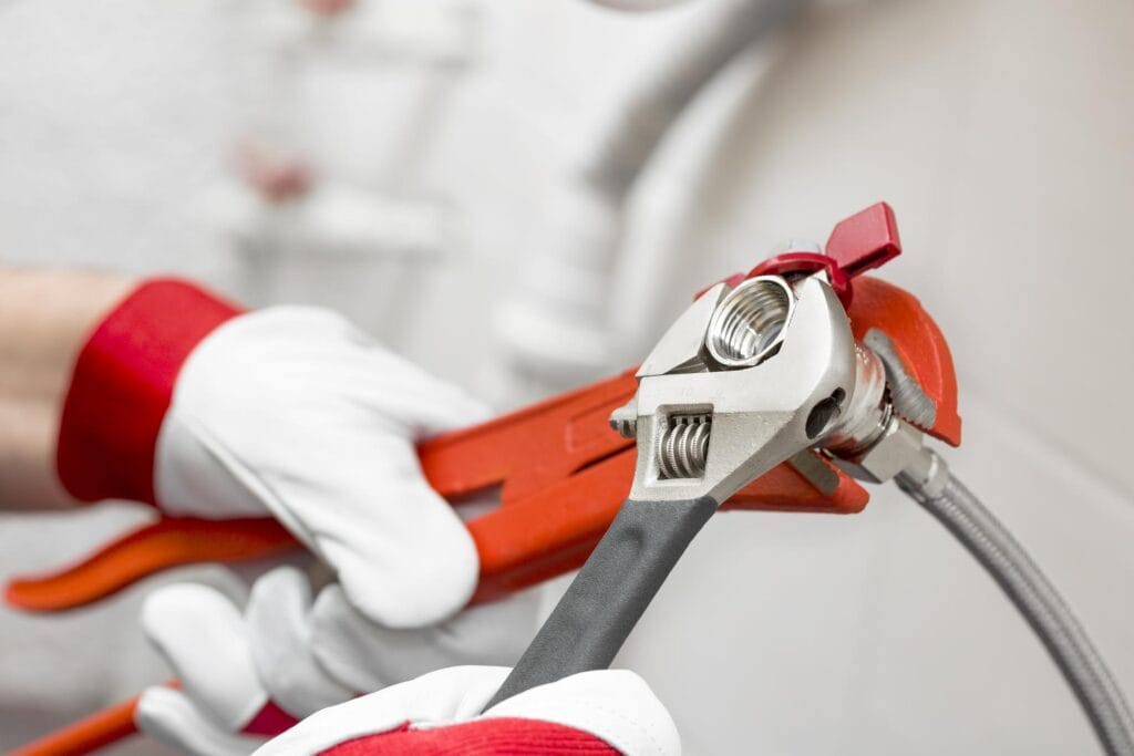 Plumber holding pipe wrenches for an emergency repair in Indio
