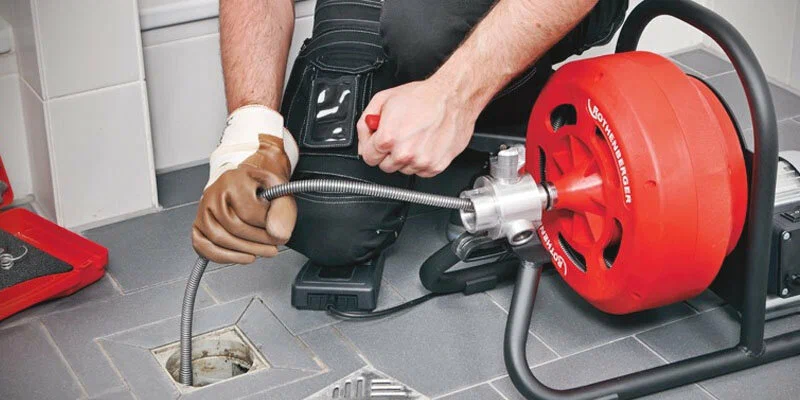 Plumber using a drain-cleaning machine in Indio