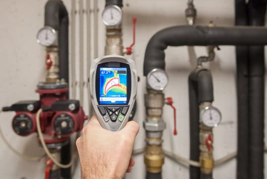 Plumber using a thermal imaging camera to inspect pipes in Indio