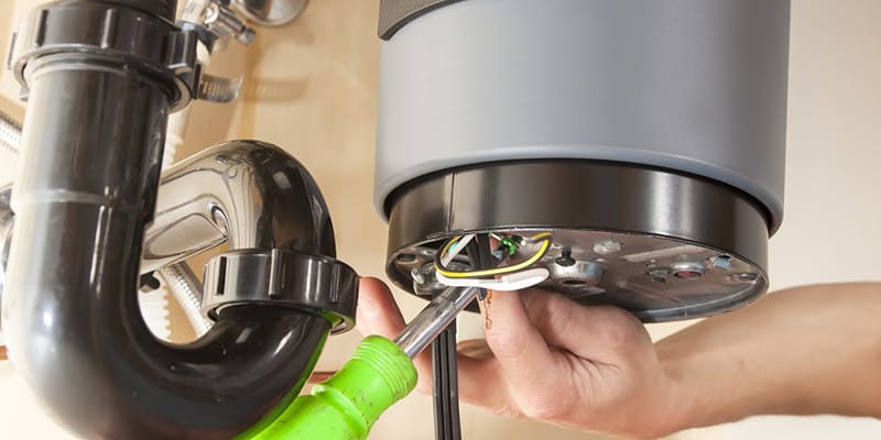 Technician repairing the heating element of a water heater in Indio