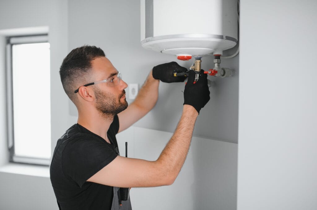 Technician performing water heater maintenance in Indio